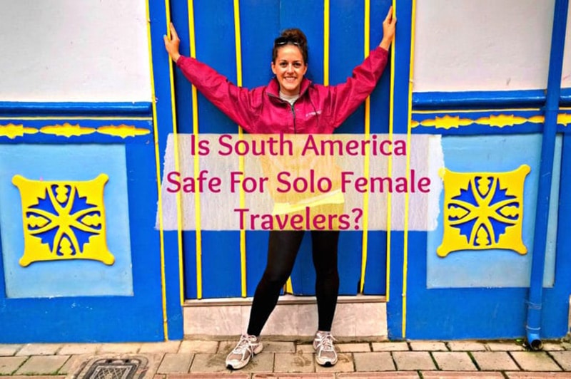 一名女子在哥伦比亚旅行时，在蓝黄相间的门口摆姿势