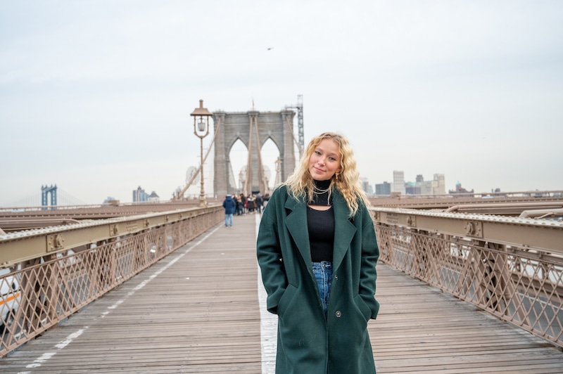 一名女子独自前往纽约，走在布鲁克林大桥上